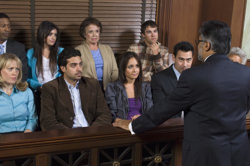 Rear view of a advocate communicating with the jurors in the court house